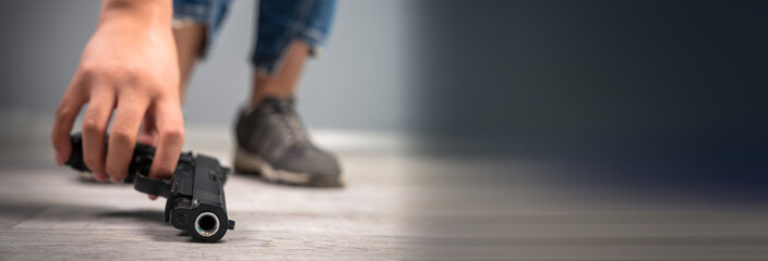 Woman picking up a gun from the floor