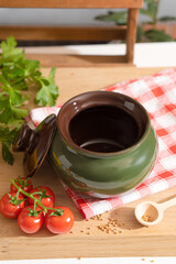 Baking dish on the kitchen table among vegetables and herbs