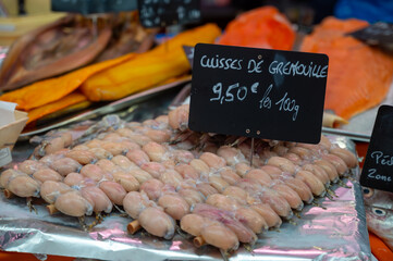 Assortment of meat on weekly food market in France, English translation: frog legs, price by 100 gr