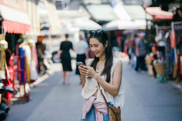 Fototapeta premium Happy Asian woman sightseeing around the city, visiting local market.