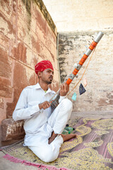Indian street musician playing Ravanahatha traditional instrument in Rajasthan