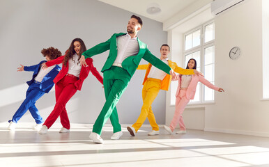 Vibrant group of a dancing people in colorful business suits, smiling as they dance energetically. The lively atmosphere and upbeat music create a joyous dance party with a happy crowd of dancers.