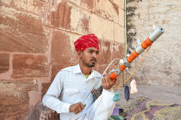 Indian street musician playing Ravanahatha traditional instrument in Rajasthan