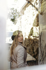 A woman stands behind a glass door.