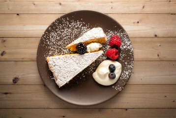 plate with slice of cake with fruits over wooden table
