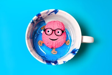 Anthropomorphic Brain Floating on Inflatable Ring inside a Cup