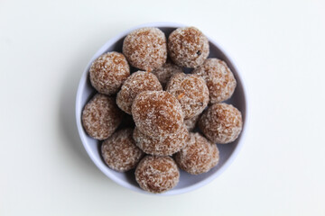 Tamarind candy balls in white bowl. Isolated on white background, flat lay or top view