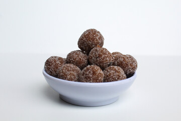 Tamarind candy balls in white bowl. Isolated on white background