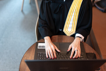 Top view of Asian female lawyer's hand working Typing with a laptop, wearing a legal suit, representing clients and defendants online while waiting to mediate. Submit a complaint to the prosecutor - obrazy, fototapety, plakaty