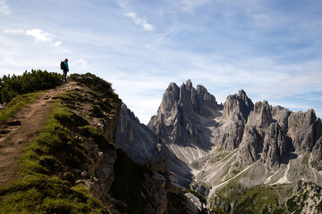 Stunning view of a tourist on the top of a hill enjoying the view of the Cadini di Misurina
