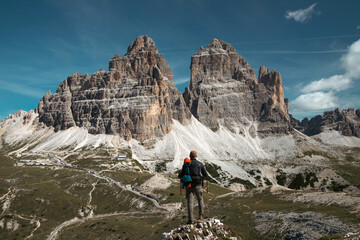 Stunning view of a tourist enjoying the view of the Tre Cime Di Lavaredo, Dolomites, Italy.