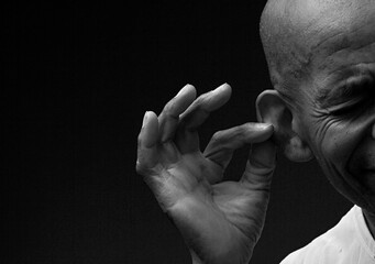 deaf man suffering from deafness and hearing loss on grey background with people stock image stock photo	