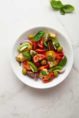 Overhead view of tomato crouton salad with pesto