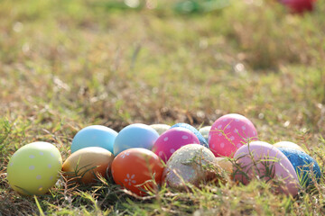 Colorful Easter eggs on green grass nature garden in wild meadow. Greetings and presents for Easter Day. Happy spring holiday celebration.