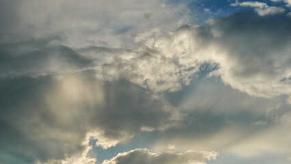 White fluffy clouds in the sky. Blue sky and cloud cover on a sunny summer day. Empty background, copy space