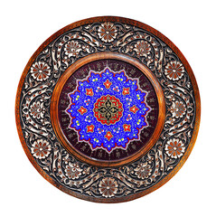 The carved wooden plate is decorated with bright oriental patterns and ornaments.Round ornament of Arabic style.