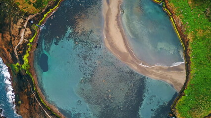 Drone amazing turquoise lagoon on summer day. Calm water washing wild shore