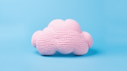 Knitted toy pink cloud on a blue background. Children's clothes and accessories. View from above.