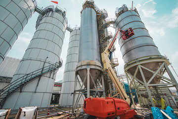 Male industry working at high in a boom liftinspection tank silo © chitsanupong