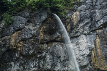 The waterfall creates a flow through the rocks, revealing the majesty of the mountains and forests...