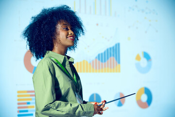 African-American woman presenting statistical data with pointer against projected graph background...