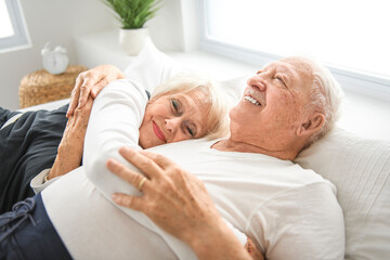 Fototapeta na wymiar Senior 80 years old Couple Relaxing In Bed together