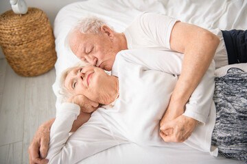 Fototapeta na wymiar Senior 80 years old Couple Relaxing In Bed together
