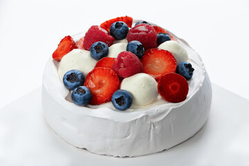 Pavlova dessert with strawberries, blueberries and raspberries isolated on a white background