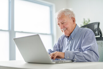 senior men using a laptop while sitting at the office