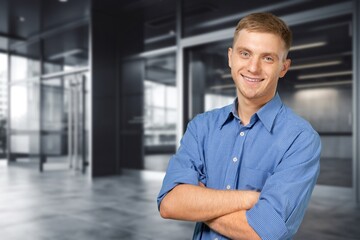 Headshot of confident male businessman on office background.