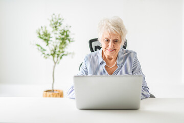 senior women using a laptop while sitting at the office