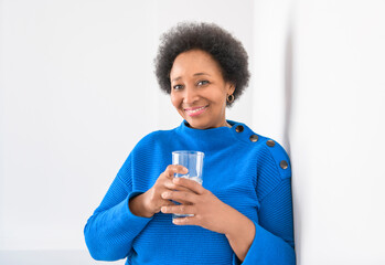 Fototapeta na wymiar senior black American woman on white background with cold water glass