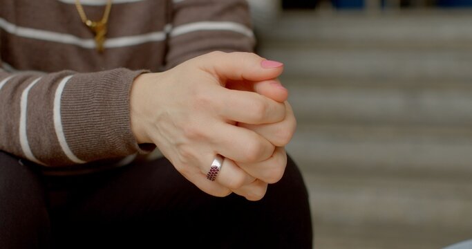 Close-up hands clasped and fingers inside as sense of reservation or inhibition. Convey hesitancy, mistrust, or desire to retreat from outside world. Body language - signal internal tension or stress.