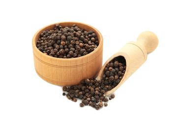 Black peppercorns in wooden bowl and spoon isolated on white background.