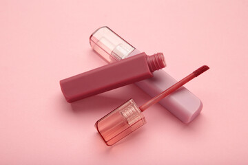Lip gloss bottle on pink background. Macro photo