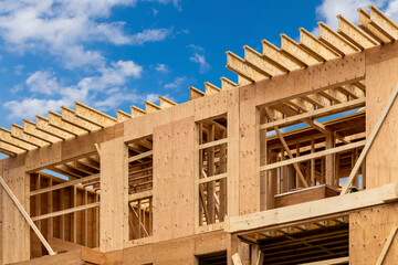 Plywood sheathing and engineered wood joists or rafters forming the roof of a house under...