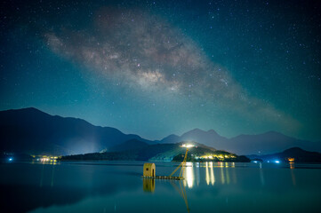 Beautiful view of the Milky Way from the pier on the lakeside of the mountains. Sun Moon Lake is...
