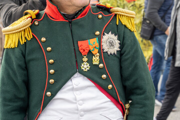Historical reenactment of events. The reign of Emperor Napoleon I Bonaparte. Close-up of the upper part of Napoleon's military uniform with orders.