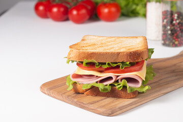 Close-up of two sandwiches with bacon, salami, prosciutto and fresh vegetables on rustic wooden cutting board. Club sandwich concept - 752430720