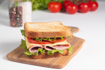 Close-up of two sandwiches with bacon, salami, prosciutto and fresh vegetables on rustic wooden cutting board. Club sandwich concept - 752430751