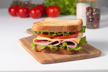Close-up of two sandwiches with bacon, salami, prosciutto and fresh vegetables on rustic wooden cutting board. Club sandwich concept - 752430756