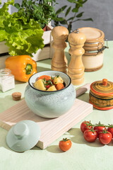 Baked potatoes with carrots in a clay pot in the kitchen