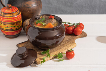 Meat goulash with vegetables in a pot on the kitchen table