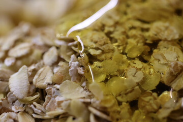 Corn flakes with rolled oats and honey background. Macro closeup.