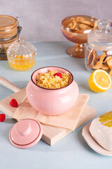Millet porridge with raspberries in a clay pink pot