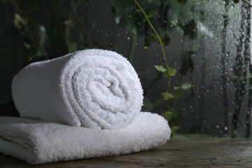 White terry towels on table in bathroom, space for text