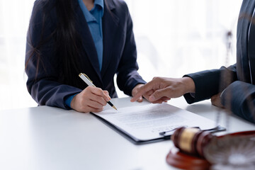 Lawyer discussing a contract with a client. Legal consultation and agreement review concept.
