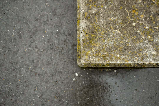 Betonmauer mit Asphaltboden im Hintergrund.