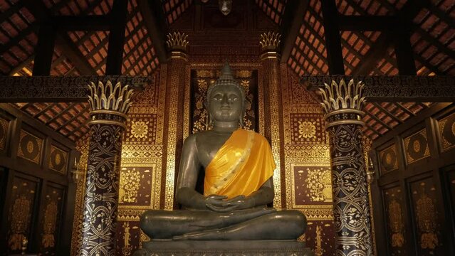 view inside Thai buddhism temple in northern of thailand with art statue of the big buddha inside wooden building