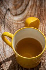 Teapot (French press) with half lemon and teapot at wooden table on the balcony, morning tea time, aromatic aromatherapy fresh and herbal, organic tea from farm. In background neighborhood buildings